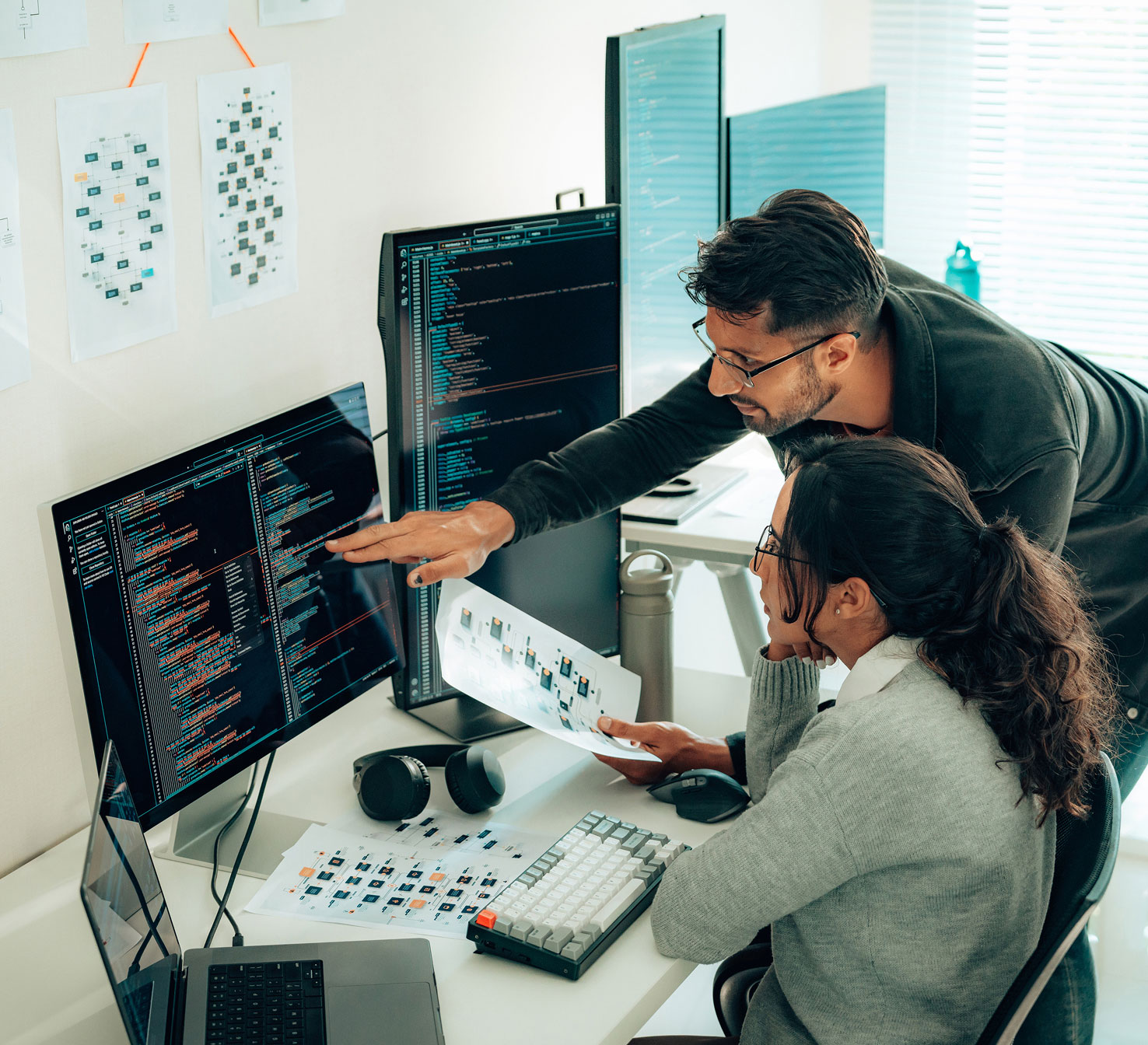 Two students looking at computer screen with code on it